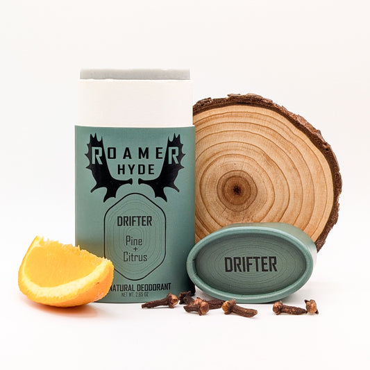Roamer Hyde Drifter Pine Citrus natural deodorant packaging with a wooden slice and lemon wedge on a white background